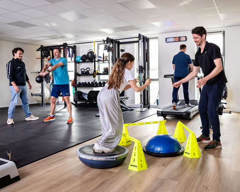 Fysiotherapie RijswijkBuiten Oefenzaal waar mensen alleen of onder begeleiding aan het oefenen zijn